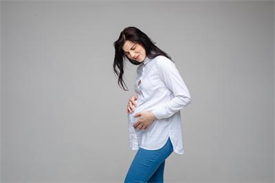1703582081497842.jpg 千库网_美丽的女性怀孕了,在灰色的工作室背景下触摸怀孕的腹部感觉疼痛。_摄影图编号16007043.jpg